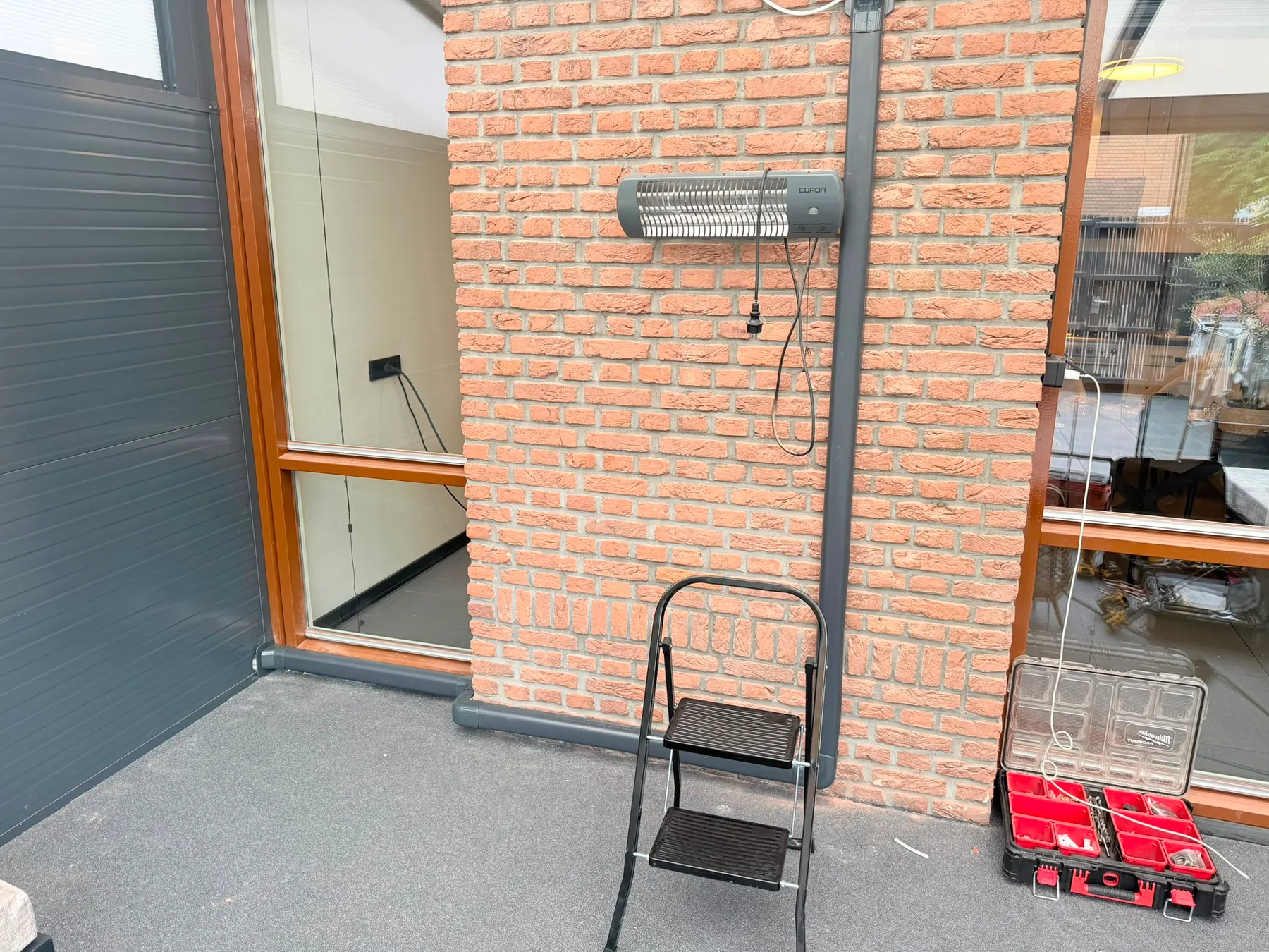 Leidingwerk tijdens de montage aan een bakstenen gevel