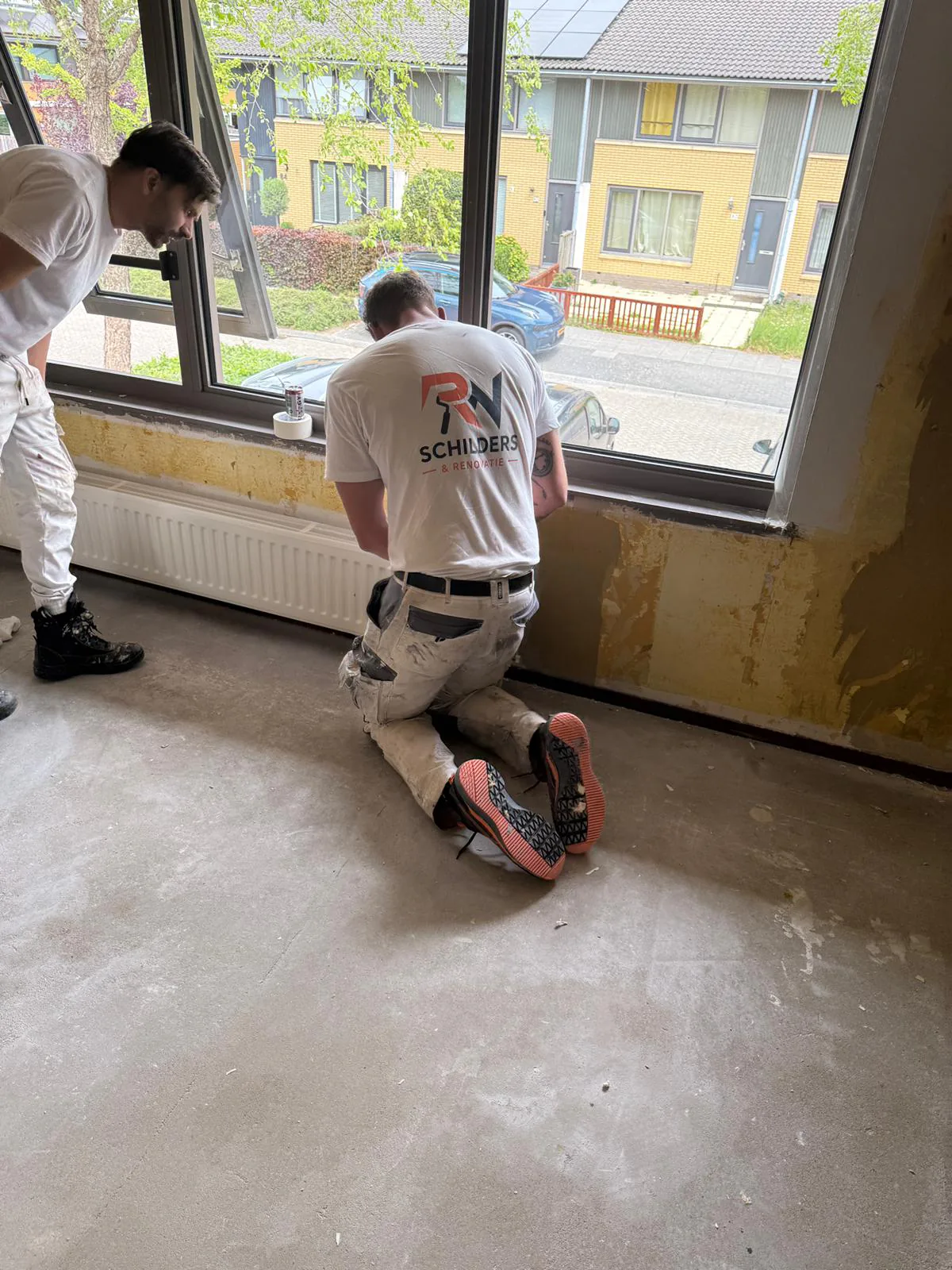 Team van RN Schilders aan het werk bij een woning in Almere met uitzicht op de straat