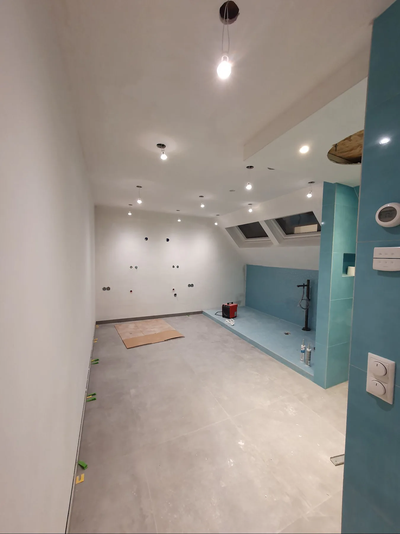 Zolderbadkamer in renovatie met turquoise tegelwerk