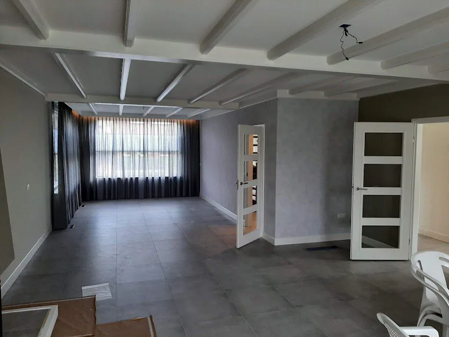 Woonkamer met wit geschilderd balkenplafond