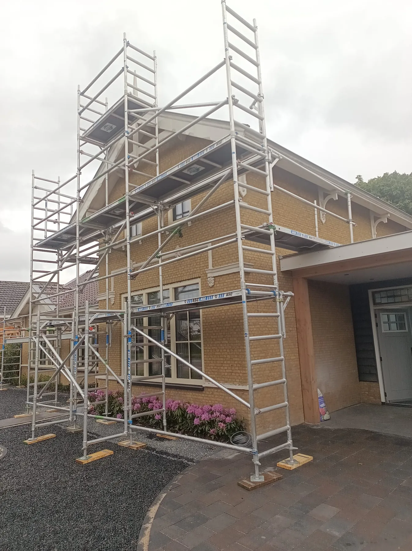 Steigers rond de voorgevel van een woning in Ridderkerk