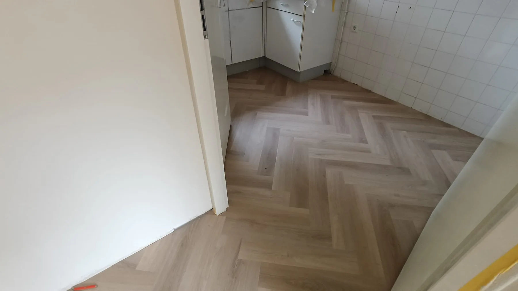 Lichte visgraatvloer doorgelegd tot in de keuken