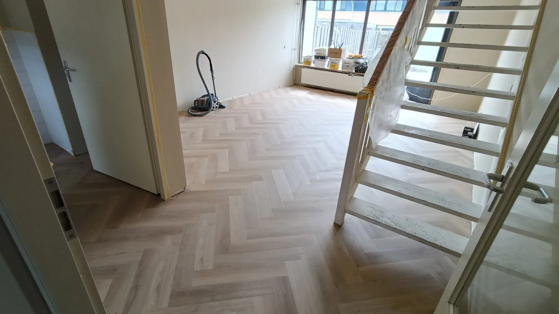 Doorlopende visgraatvloer rondom een open trap