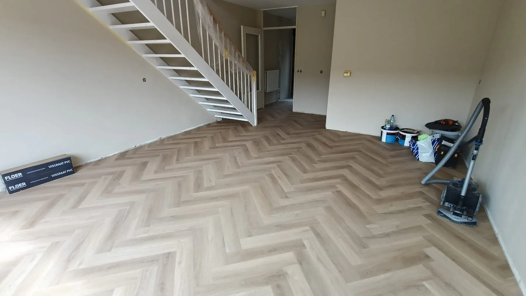 Lichte visgraatvloer doorgelegd in een woonkamer en hal