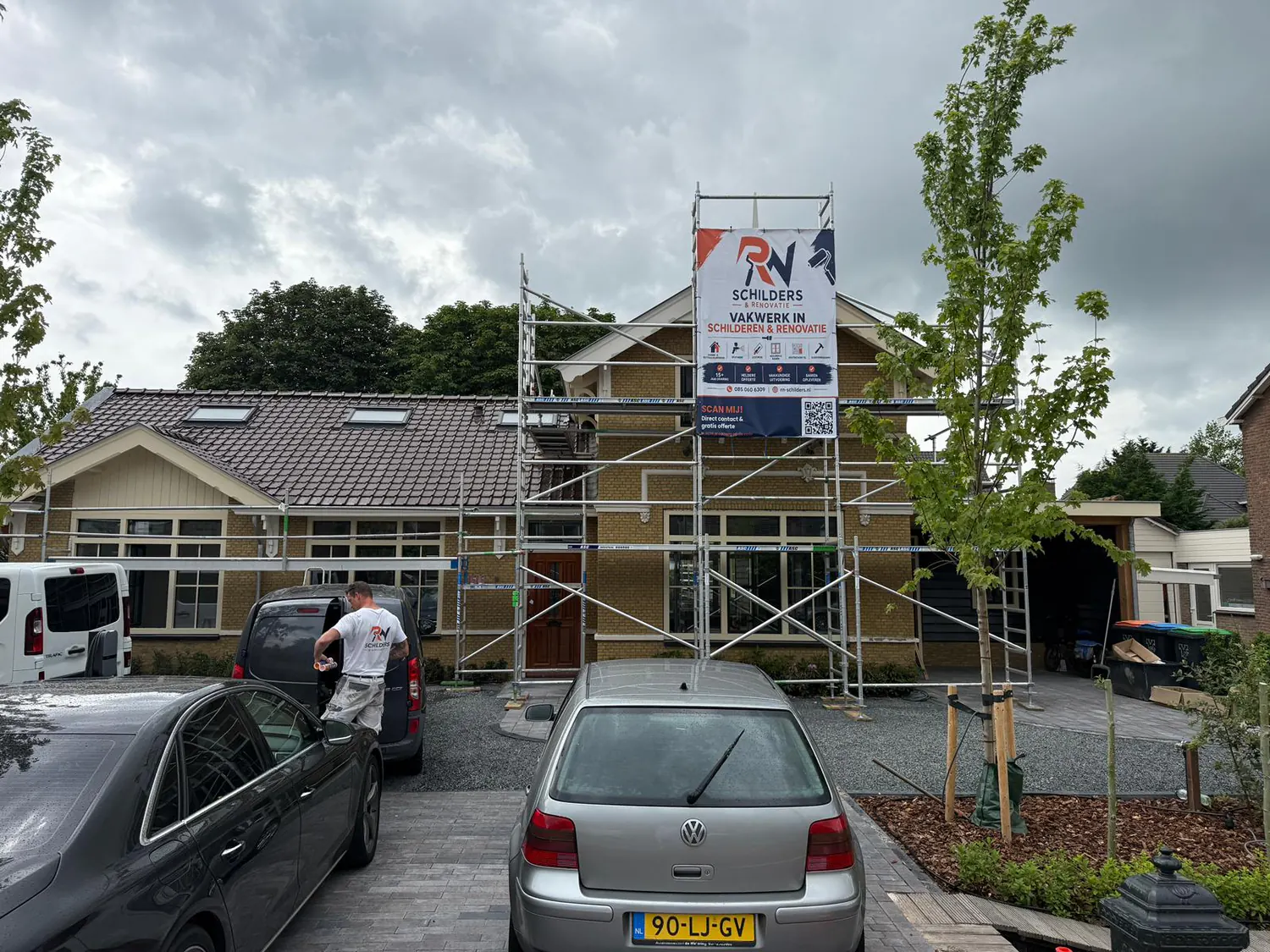 Woning in Woerden in de steigers met RN Schilders spandoek tijdens buitenschilderwerk